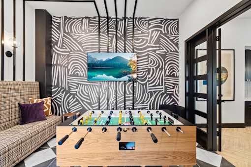 a living room with a foosball table and a couch