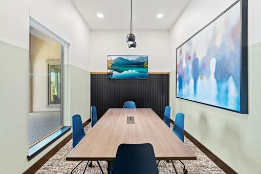 a conference room with a wooden table and blue chairs