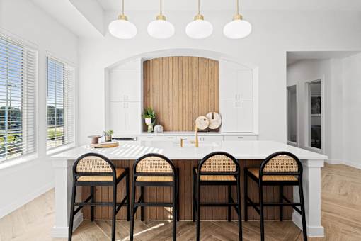 a kitchen with a white counter top and a group of chairs