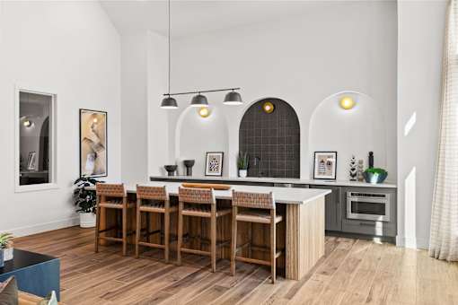Resident clubhouse featuring bar-height seating, refreshment station, and open gathering space for socializing and community events.