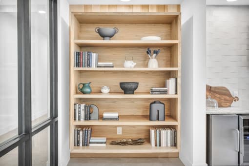 a bookshelf in a kitchen with books and vases on it