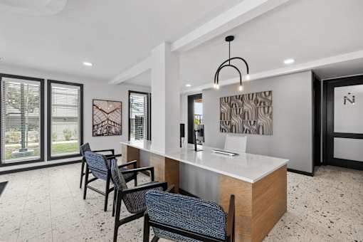 A modern office space with a reception desk and chairs.