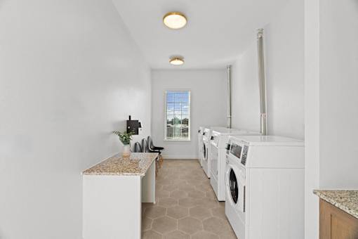 a white laundry room with white appliances and a window