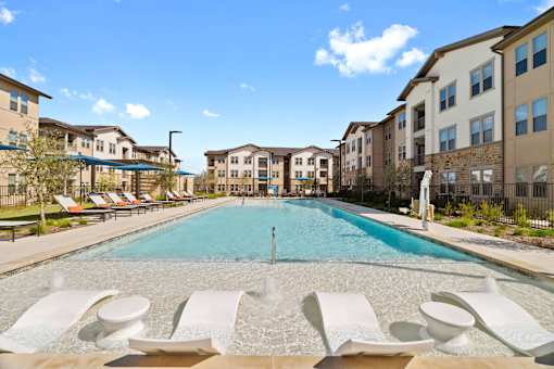 a swimming pool with apartments in the background