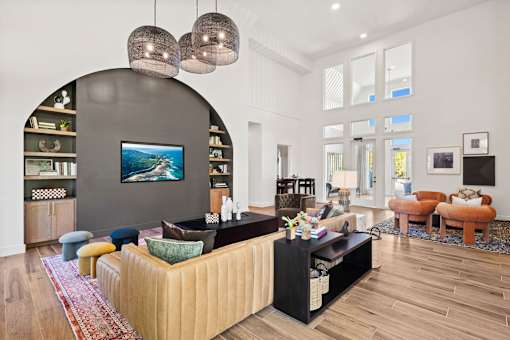 Resident lounge featuring comfortable seating, contemporary design finishes, and adjacent gathering space for socializing and relaxation.