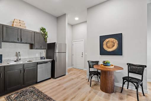 Open-concept apartment kitchen and dining area featuring stainless steel appliances, modern cabinetry, and space for everyday dining.
