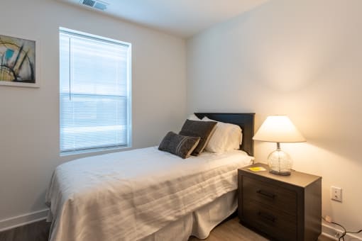 a bedroom with a bed and a dresser and a window