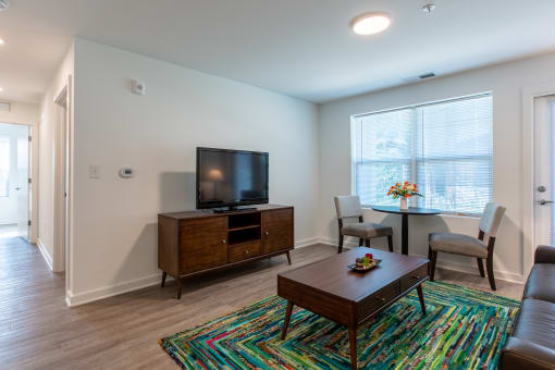 a living room with a television and a table and chairs