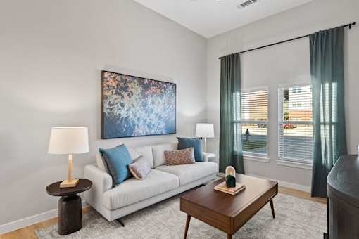 Apartment living room featuring comfortable seating, abundant natural light, and contemporary interior finishes.
