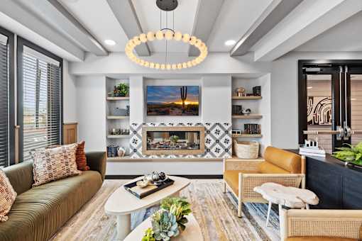 A modern living room with a fireplace and a large painting above it.
