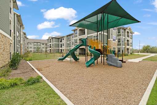 A playground with a green slide and a yellow slide.