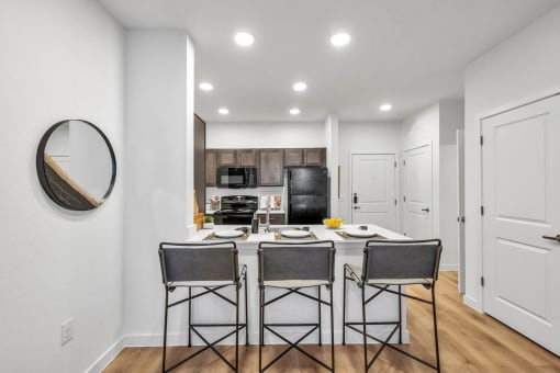 a kitchen with a bar and stools in a living room