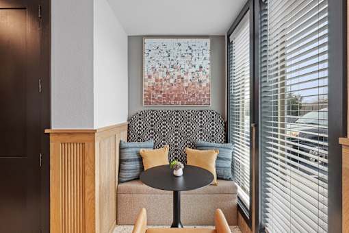 A room with a couch, a table, and a painting on the wall.