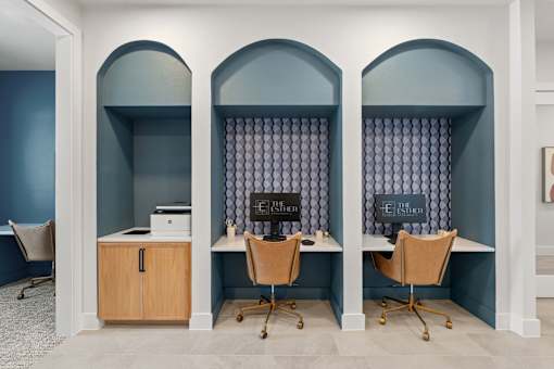 Coworking-style business center at The Esther with desktop computers, chairs and printer.
