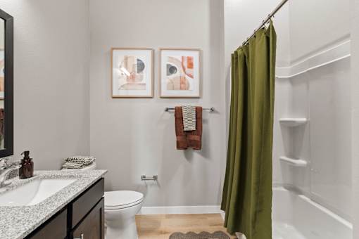 Full bathroom featuring a tub-shower combination, granite-style vanity countertop, and contemporary finishes.