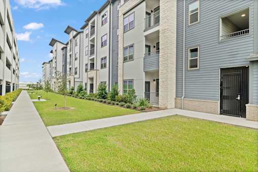 Residential building with modern façade elements, private outdoor balconies, and landscaped community courtyards.