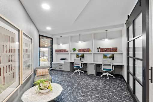 A modern office space with a grey carpet and white walls.