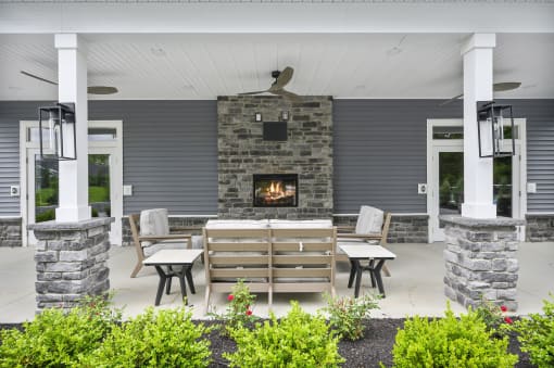 the screened porch has a stone fireplace and wooden furniture