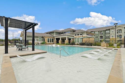 A large outdoor swimming pool with a sunshade.