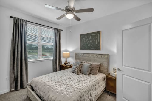 a bedroom with a bed and a ceiling fan