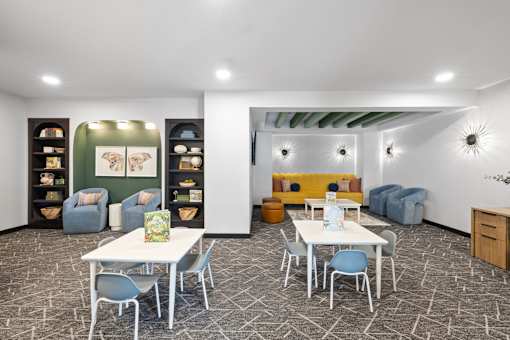 A room with a white table and blue chairs.