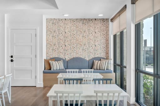 a dining room with a blue couch and a white table and chairs