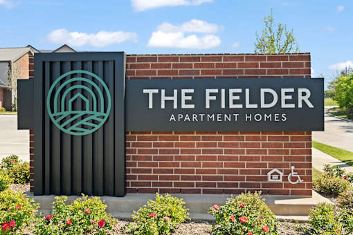 Community entrance monument sign displaying The Fielder Apartment Homes branding and property identification.