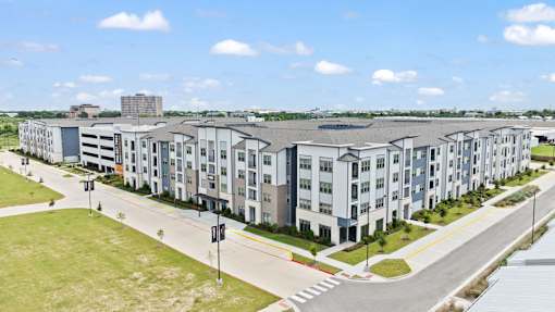 Residential apartment community featuring contemporary architecture, integrated parking, and landscaped surroundings.