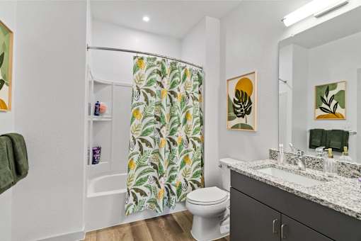 a bathroom with a shower curtain and a sink and a toilet