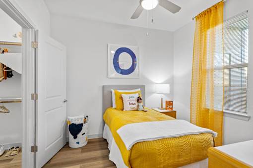 a bedroom with a yellow bed and a ceiling fan