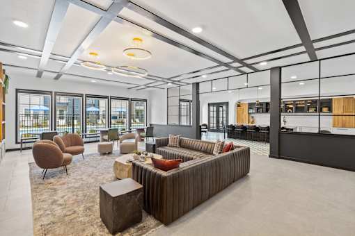 Apartment community lounge at Aviator 1518 with lounge seating, tables and kitchenette area.