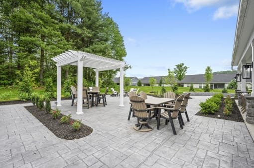 a patio with a table and chairs and a white pergola