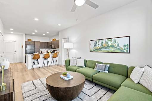 a living room with a green couch and a round coffee table