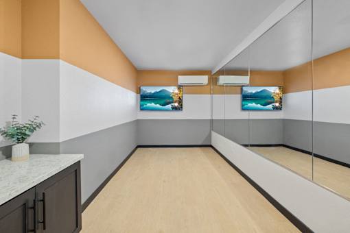 A long, narrow hallway with a plant on the counter and two paintings on the wall.