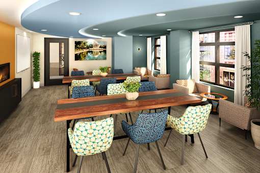 Stylish shared workspace featuring long wood tables, comfortable seating, and a bright window-lined lounge area.