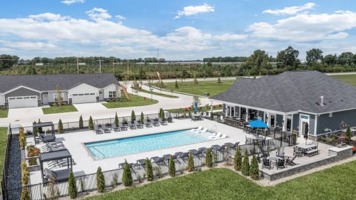 an aerial view of a pool and a house with a patio and a swimming pool