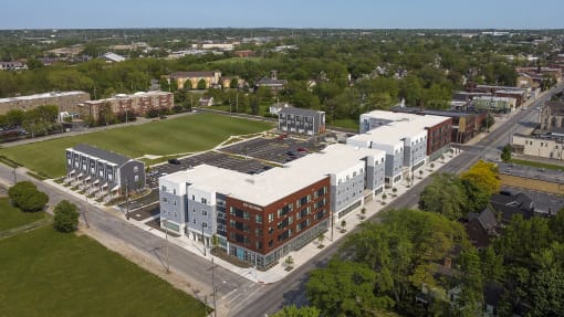 an aerial view of an apartment complex with a football field in the background