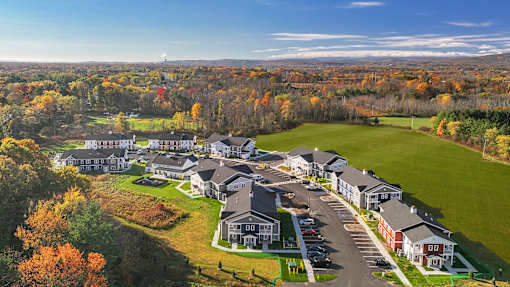 A large building complex surrounded by trees in autumn.