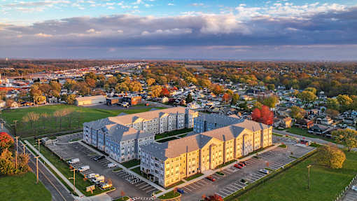 Aerial view of the apartment community featuring modern residential buildings, parking areas, and landscaped surroundings within a neighborhood setting.