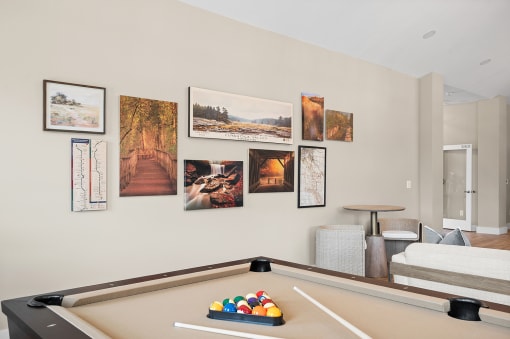 a living room with a pool table and pictures on the wall