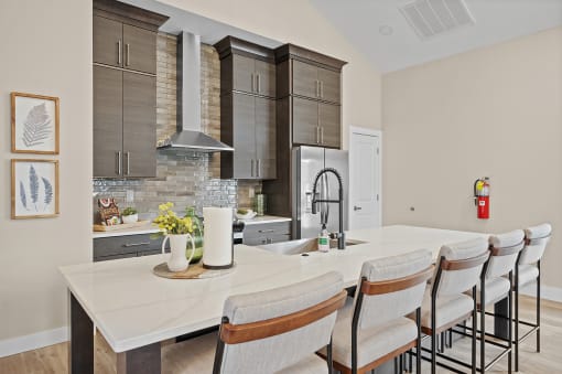 an open kitchen with a large island with white quartz countertops and a dining area