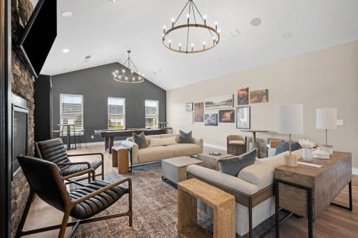 a living room with couches and chairs and a pool table