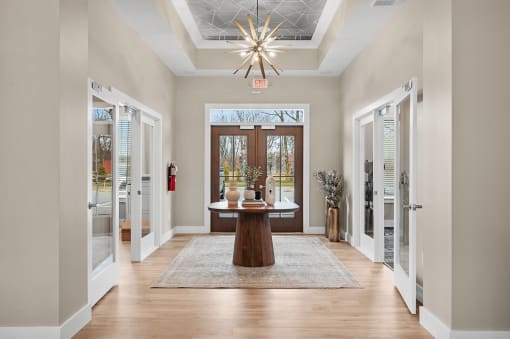 a foyer with a table in the middle of it and a chandelier