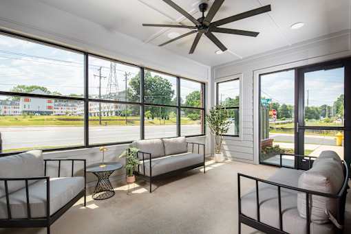 Inviting sunlit lounge with cozy seating, expansive windows, and a casual atmosphere ideal for relaxing or connecting with others.