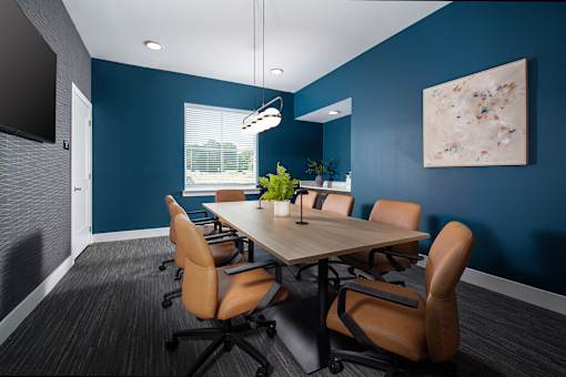 Modern conference room with a large meeting table, comfortable seating, and clean, contemporary finishes, designed for group meetings and collaboration.