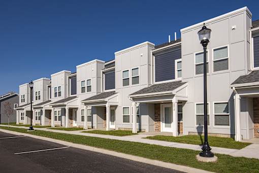 A street view of a row of houses with a lamp post in the foreground.