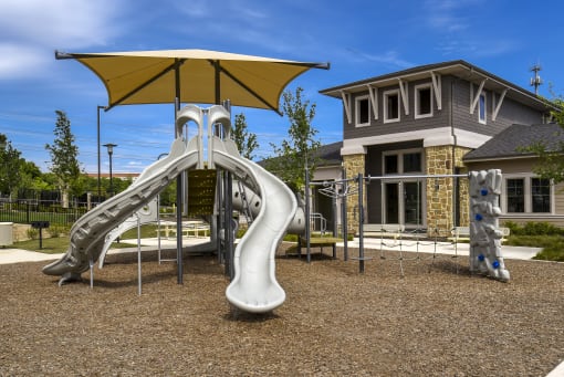 a playground with a slide and umbrella