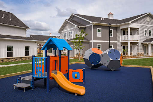 A playground with a blue slide and a yellow slide.