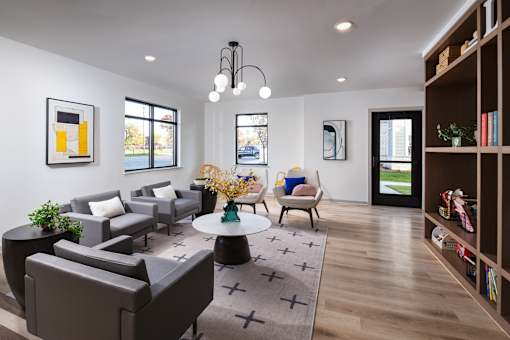 Modern resident lounge with comfortable seating, large windows, and a welcoming open layout for relaxing or socializing.