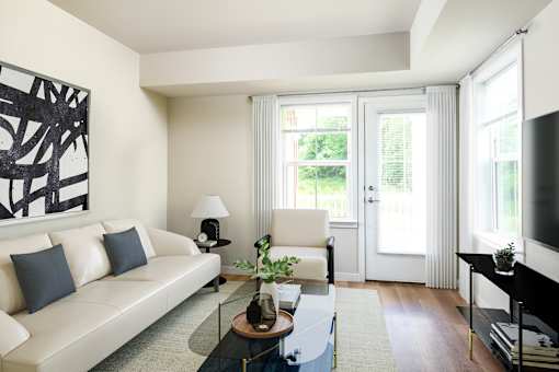 A living room with a white couch, a black coffee table, and a large abstract painting on the wall.